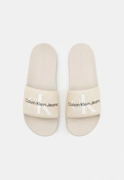 Calvin Klein Jeans SLIDE MONOGRAM - Mules - Eggshell -Calvin Klein Elegant Magasin d82e085792124d2a990e6a0685751aa6